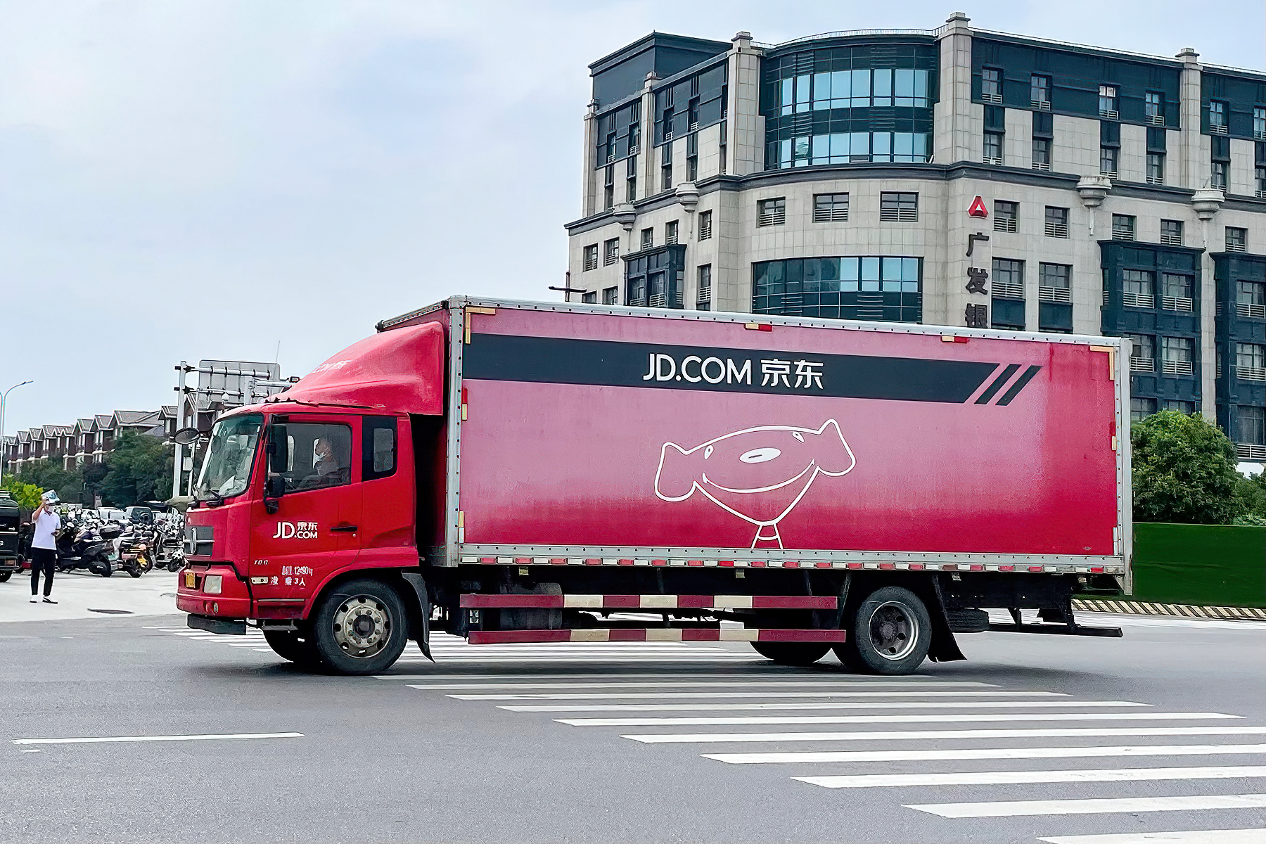 JD branded delivery truck on a city road showing the platform's real logistics network