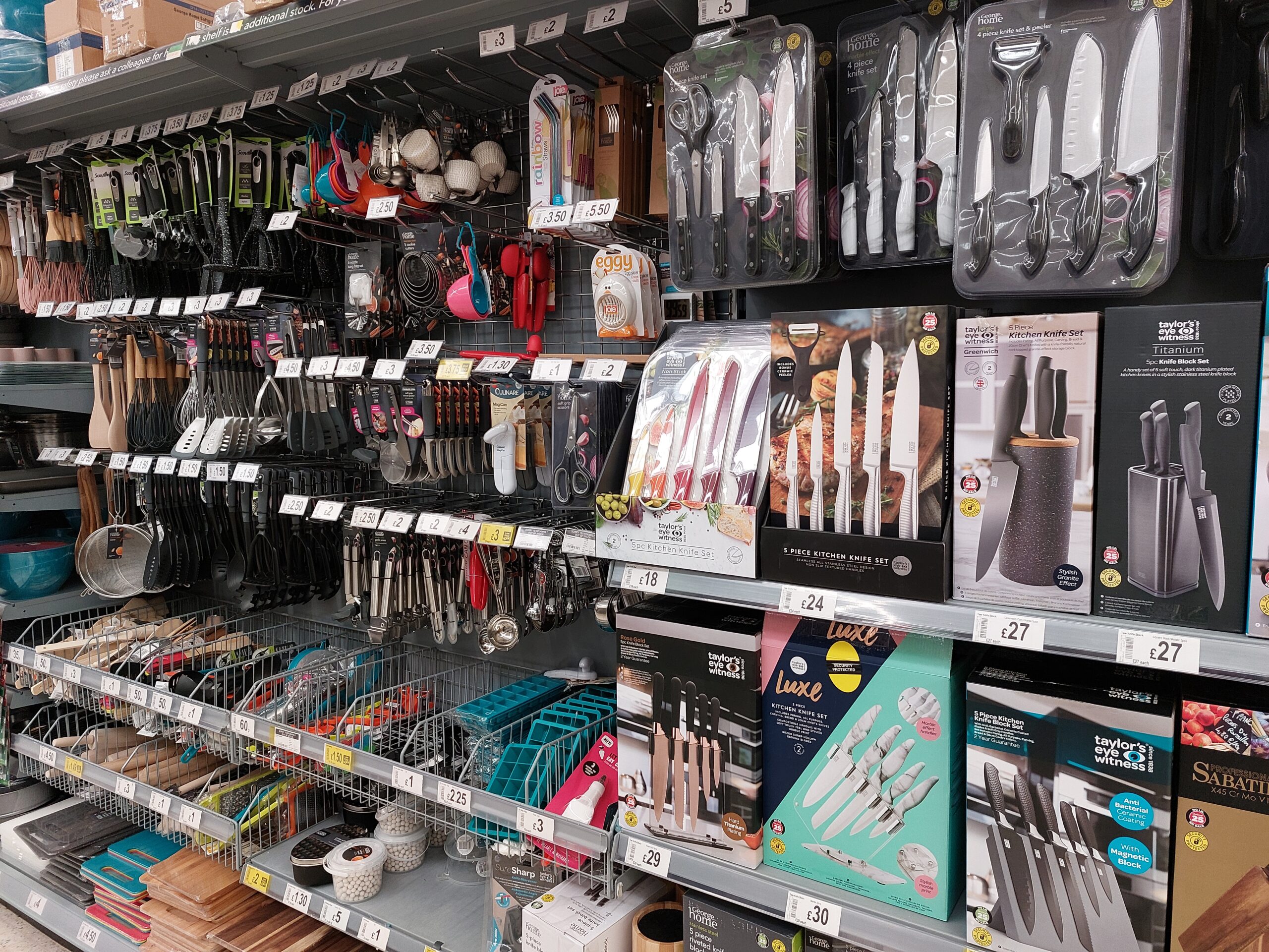 Kitchenware displayed on retail shelves inside a housewares shop