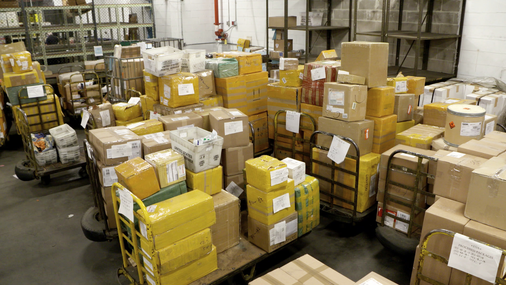 Workers processing international parcels at a mail facility
