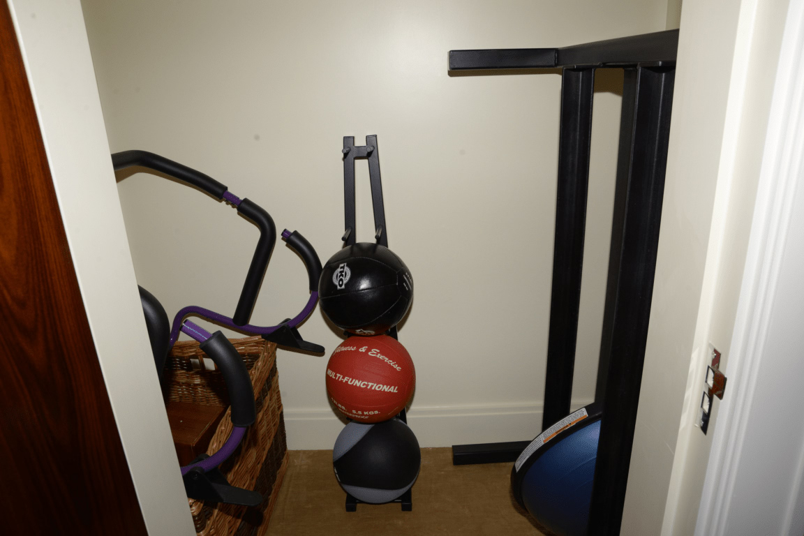 Small home gym corner with exercise equipment and a weight bench