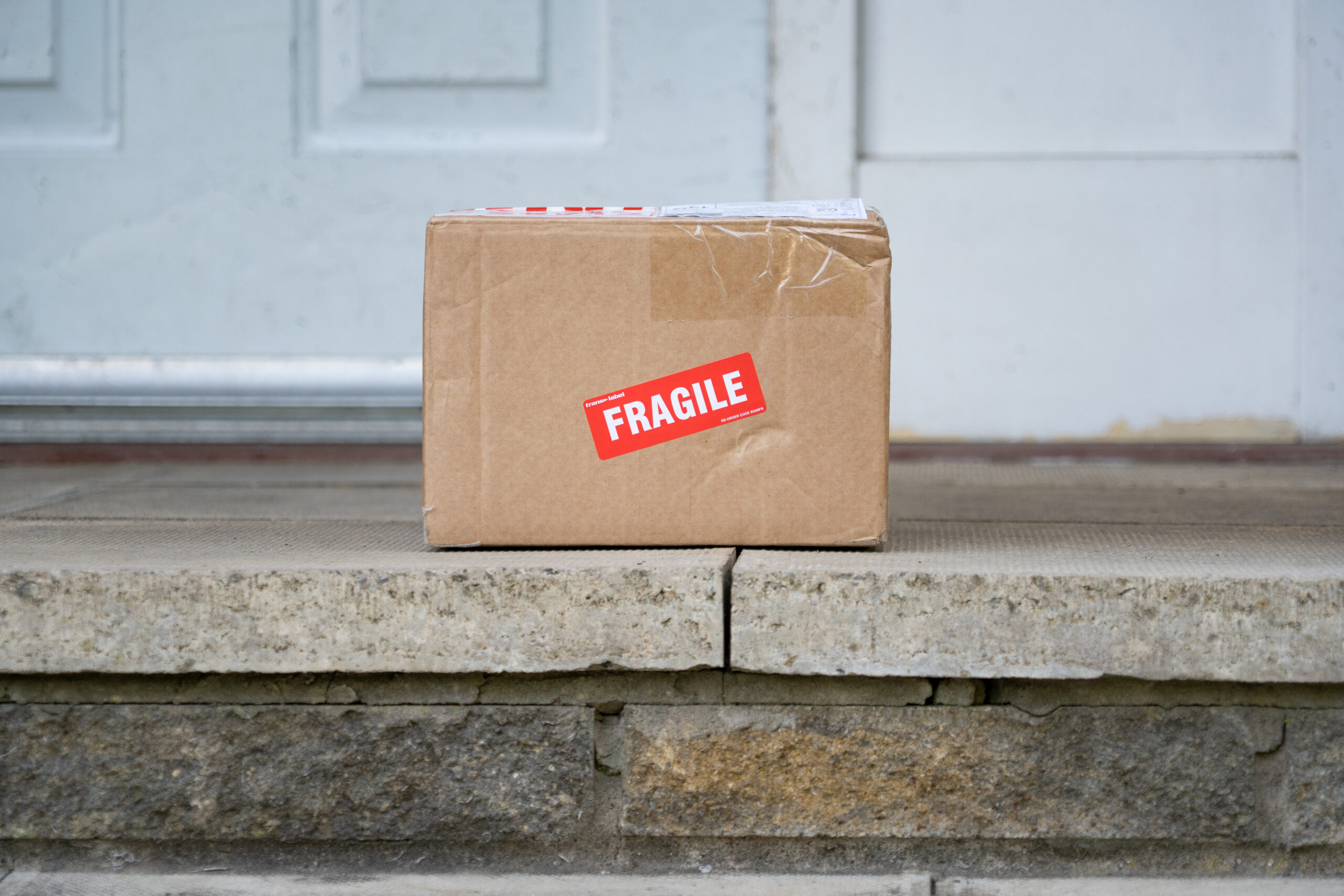 Damaged cardboard box labelled fragile showing packing risk