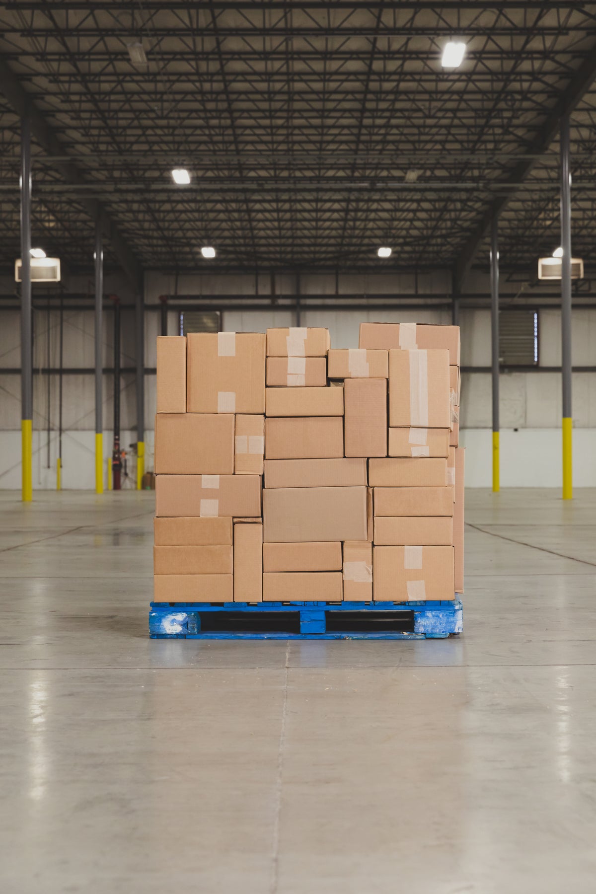 Stacked export cartons with shipping labels in a consolidation warehouse