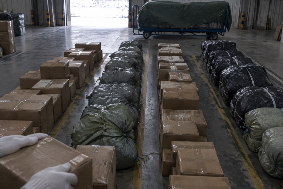 Packed mailers and a carton waiting on a packing bench